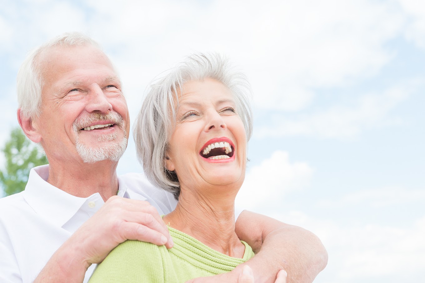 Portrait from a happy senior couple in front of cloudy sky